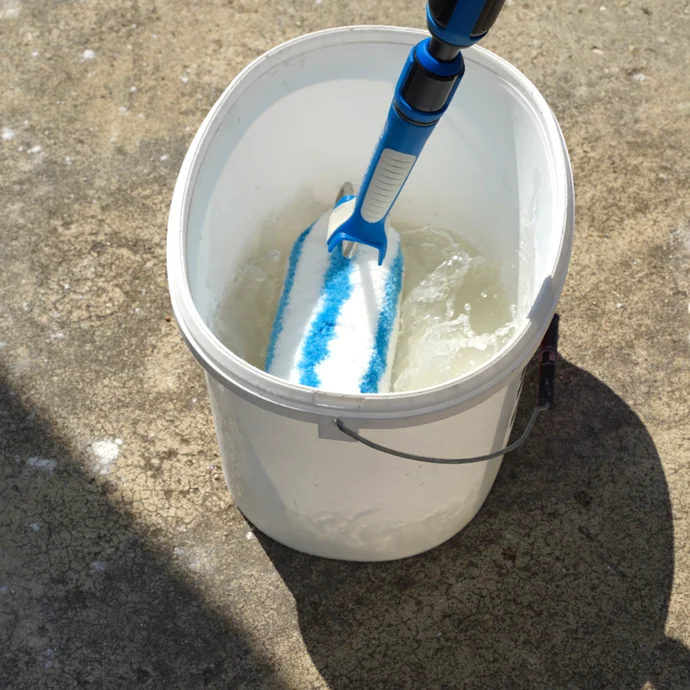 Die Farbwalze wird in einem Eimer Wasser angefeuchtet.