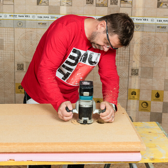 Der Baumit Heimwerker fräst den benötigten Platz für die Kabelführung auf der Unterseite der Holzfaserdämmplatte aus.