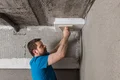 Die Kellerdeckendämmplatte wird mit einem Reibebrett angedrückt.
