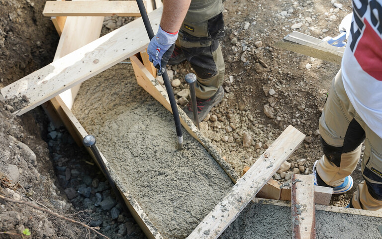 Sobald ausreichend Baumit Trockenbeton in der Schalung ist, wird der Frischmörtel für das Fundament mit einer Rüttelflasche bzw. einem Innenrüttler verdichtet.