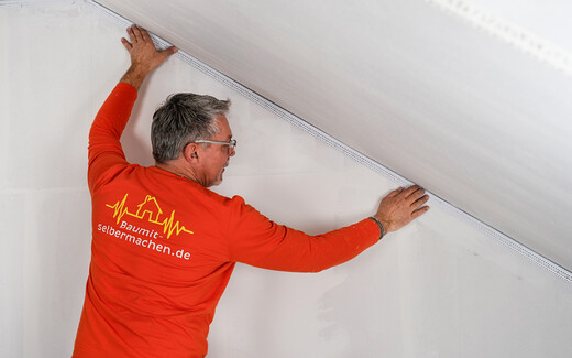 Zugeschnittene Anschlussprofil wird in den vorgesehenen Spalt an der Ecke der Innenwand gesetzt.