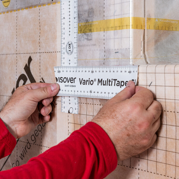 Das Klebeband Vario MultiTape SL+ von ISOVER wird ausgerichtet und aufgeklebt.
