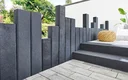 Moderne Terrasse grauen, hellen Steinplatten und Palisaden in Anthrazit.
