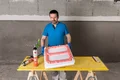 Un bricoleur utilise un matériau de remplissage pour remplir un coffrage de mousse de construction sur un établi pour un projet de bricolage.