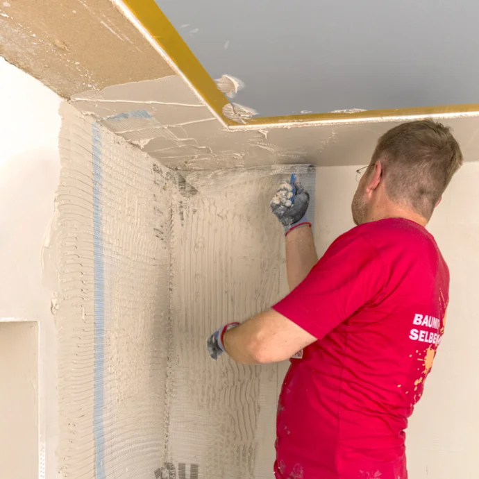 Heimwerker verputzt Deckenwand mit Baumit-Materialien für glattes Finish. Schritt-für-Schritt Projektanleitung.