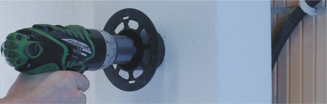 Bohrmaschine mit Lochs&auml;ge bohrt pr&auml;zise L&ouml;cher in Wand, ideal f&uuml;r Heimwerkerprojekte im Innenausbau.