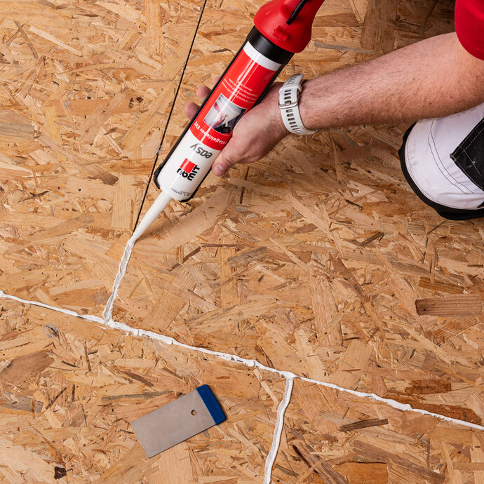 Photo de détail : les joints des panneaux d'aggloméré au sol sont étanchés avec la colle de montage easy EVO de Baumit.