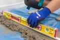 Mit Wasserwaage und Meterstab richtest du die Abziehlehre aus.