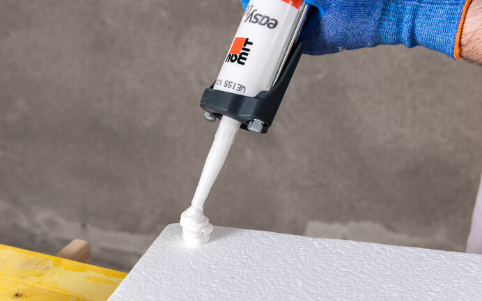 Des points de colle avec la colle de montage easy EVO sont placés aux extrémités des coins du panneau isolant EPS avec rainure et languette.