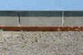 Detail einer Außenwand mit Sockel aus Betonsteinen und sichtbarem Putz, ideal für Heimwerkerprojekte zur Fassadensanierung.