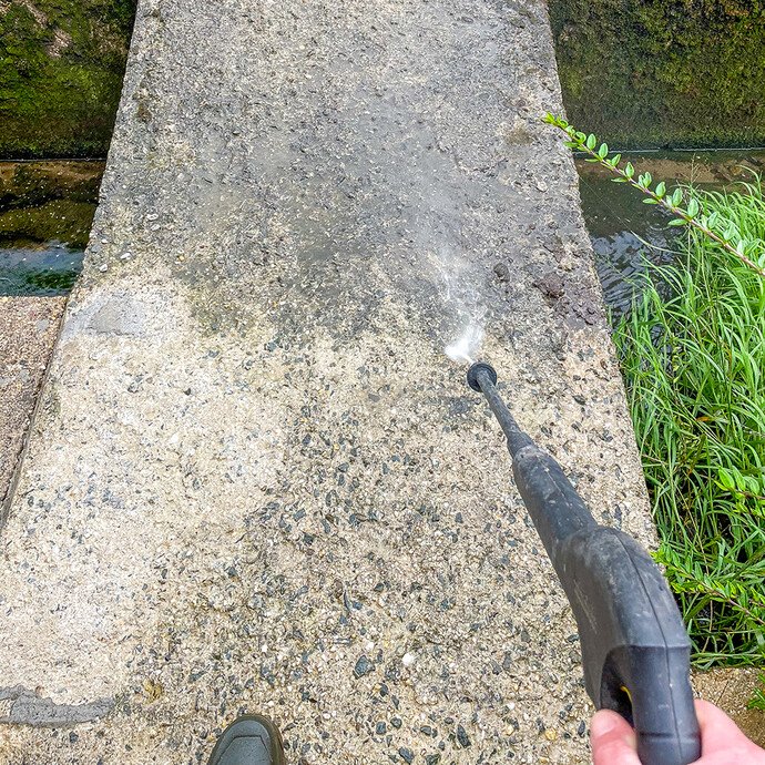 Betonuntergrund wird mit einem Hochdruckreiniger gründlich gereinigt, um Schmutz und lose Bestandteile vor der Weiterverarbeitung zu entfernen.