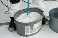 Photo détaillée : l'enduit au silicate Airless et au rouleau est mélangé à l'aide d'un mélangeur électrique.