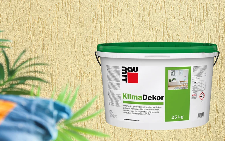 Baumit KlimaDekor Topf vor strukturierter Wand, ideal für atmungsaktive Innenputze und gesunde Wohnräume.