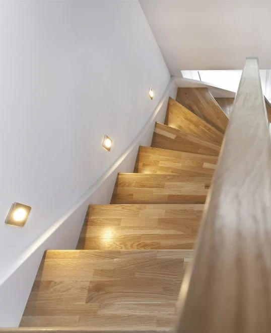 Rénovation d’escalier avec des marches en bois et un éclairage LED pour moderniser l’espace de vie.