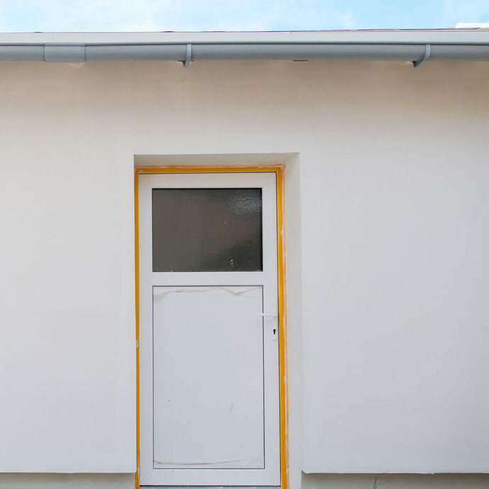 Eine Tür ist mit gelbem Klebeband an der Kante zur Wand abgeklebt.