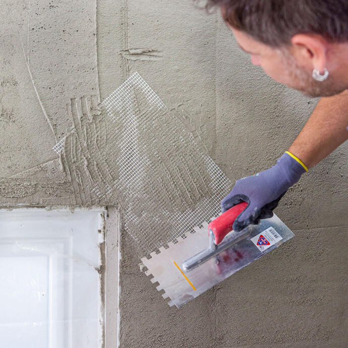 Beim Verputzen einer Wand in den Eckbereichen des Kalkzementputzes eine Streifen Armierungsgewebe einlegen