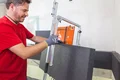 Heimwerker schneidet Dämmstoffplatte mit präzisem Werkzeug – ideal für effiziente Wärmedämmung bei DIY-Projekten.
