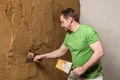 Mann beim Verputzen einer Wand für Heimwerkerprojekt mit Baumit Produkten.