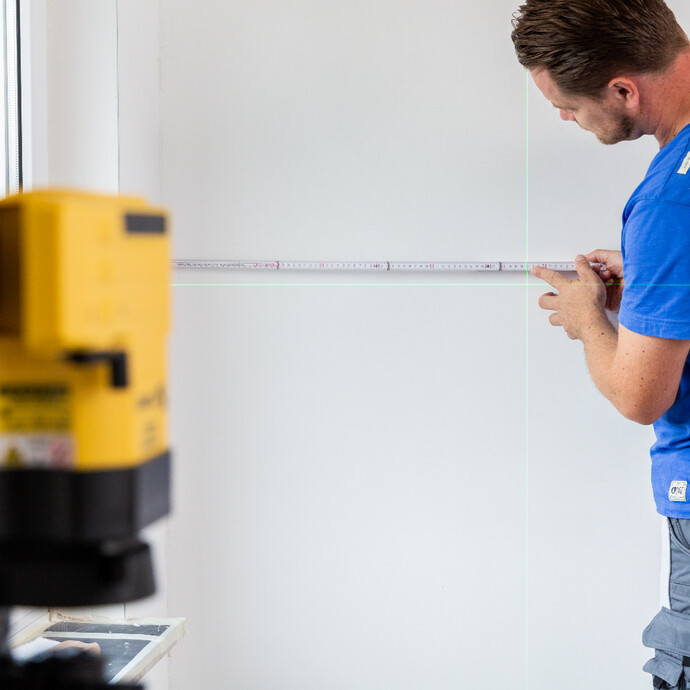 Baulaser für die erste Bahn Malervlies ausrichten