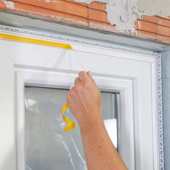 Gelbes Schutzpapier auf der Kunststofflippe an der Anputzleiste abziehen.