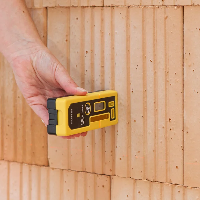 Contrôler les irrégularités d'un mur avec un laser de construction et un récepteur laser : Cela permet de détecter des écarts allant jusqu'à 20 mètres.