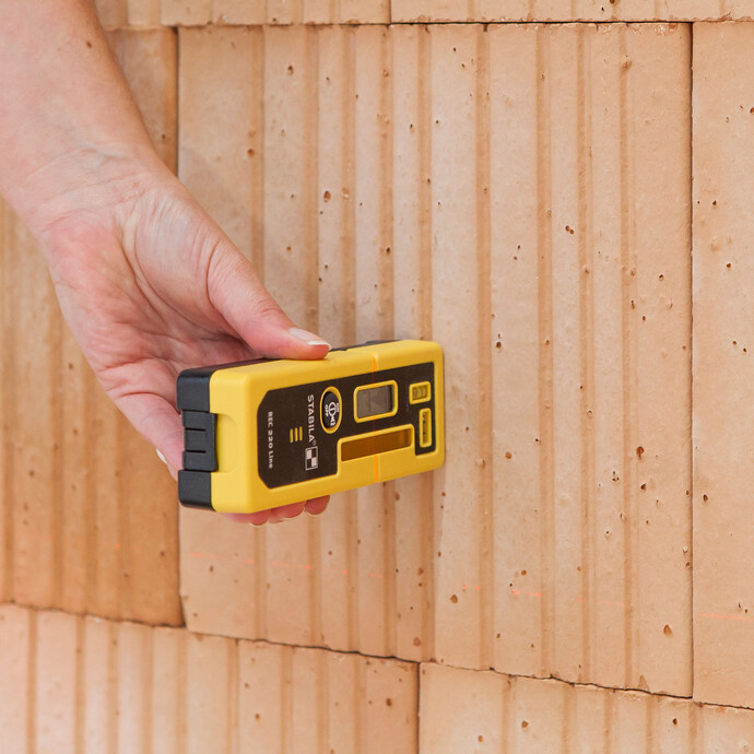 Unebenheiten einer Wand mit Baulaser und Laser-Empfänger überprüfen: Damit können Abweichungen bis zu 20 Meter erkannt werden.