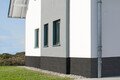 Fassade gestalten mit Baumit Mosaikputz im Sockelbereich.