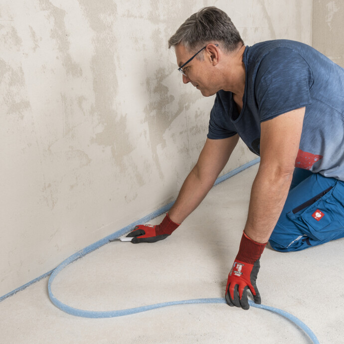 überstehenden Randdämmstreifen vor dem Verputzen der Wand abschneiden