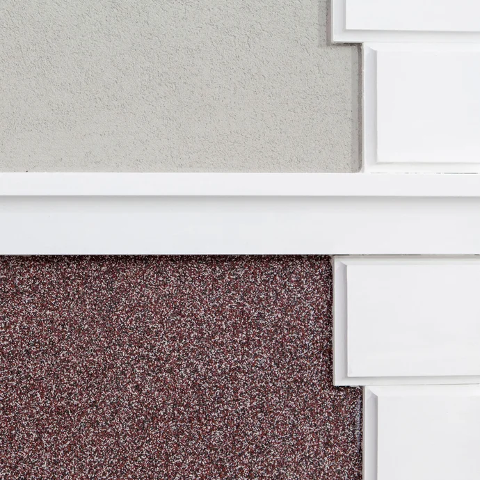 Klassische und moderne Fassade: Stuckelemente in Weiß, grauer, feiner Dekorputz mit rötlichem Mosaikputz im Sockelbereich.