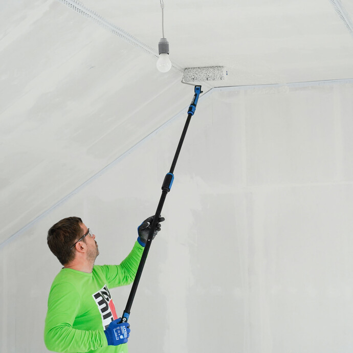 Die Spachtelmasse wird mithilfe eines Rollers mit Teleskopstange aufgetragen.