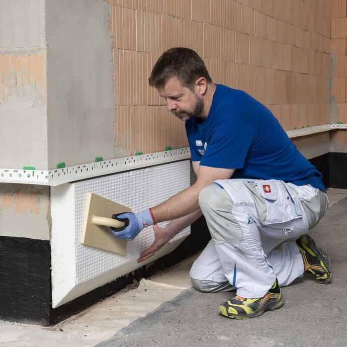 Perimeterdämmung mit Reibebrett an die Kelleraussenwand andrücken