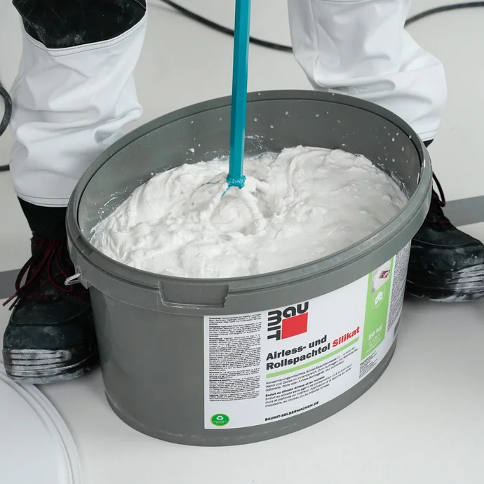 Le mastic silicate en rouleau est m&eacute;lang&eacute; &agrave; l'aide d'un agitateur &eacute;lectrique.