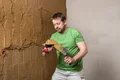 Mann verputzt Wand mit Kelle und Spachtel, Schritt für Schritt Anleitung für Heimwerker auf Baumit Selbermachen.