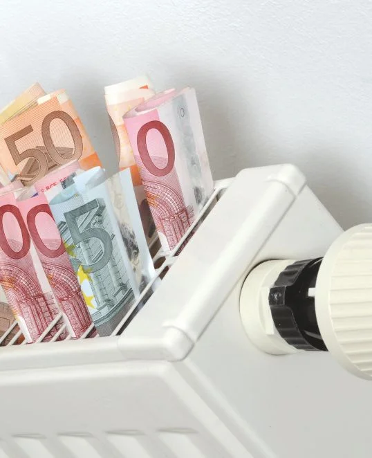 Heizkörper mit Euro-Geldscheinen symbolisiert Heizkosten und Energiesparen im Eigenheim.