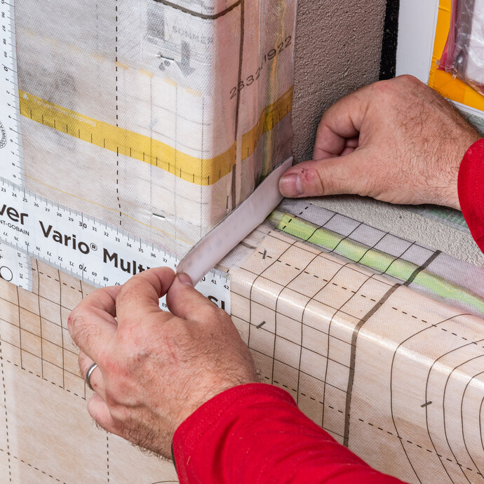 Das Klebeband wird in der Laibung angeklebt. Durch den geteilten Schutzliner kommst du sehr gut in die Ecke der Laibung, um die Dampfbremsfolie abzudichten. Baumit Anleitung für Heimwerker.