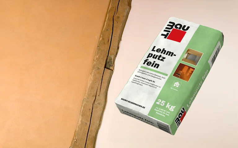 Baumit Lehmputz fein 25 kg neben verputzter Wand, ideal für glatte Oberflächen im Innenbereich. Perfekt für Renovierungsprojekte.