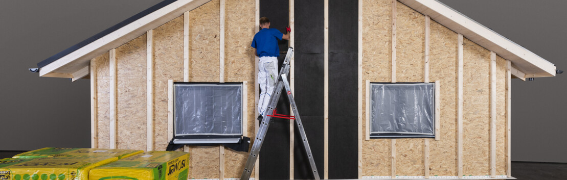 Setzen der Isover Ultimate Steinwolle in die Unterkonstruktion einer nicht hinterl&uuml;fteten D&auml;mmfassade im Au&szlig;enbereich.