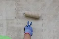 Photo détaillée – Appliquer l'apprêt de fond à l'aide d'un rouleau à peinture.