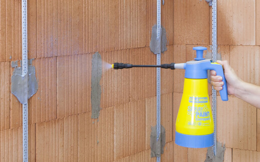 L'apprêt est pulvérisé sur la maçonnerie très absorbante afin de pouvoir ensuite enduire le mur.