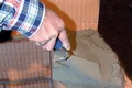 Hand verputzt mit Kelle Zementmörtel auf eine gemauerte Wand.