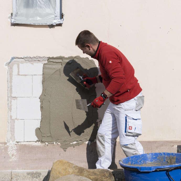 Kalkzementputz an der Wand auftragen