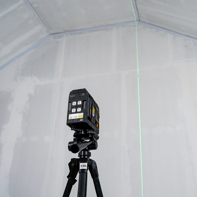 Ein Kreuzlaser strahlt eine gerade Linie auf die Wand.