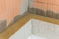 Wärmedämmung mit Dämmplatten und Putz auf Ziegelmauerwerk bei der Sanierung eines Innenraums.