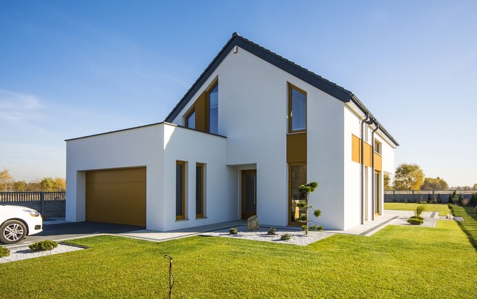 Einfamilienhaus mit weisser Putzfassade und gelben, versetzten Farbflächen