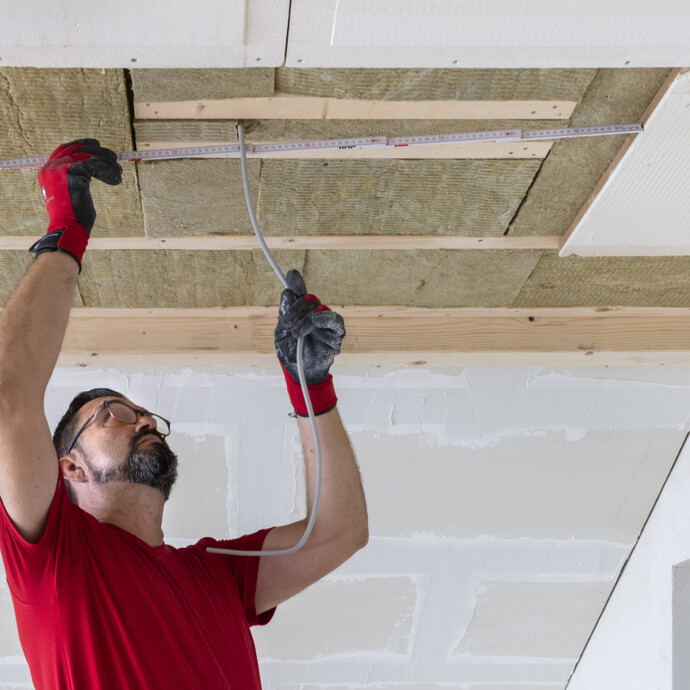 Masse für die Kabeldurchführung der Beleuchtung an der Trockenbaudecke ausmessen