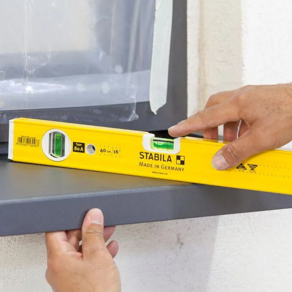Gefälle der Fensterbank vom Fenster weg mit Wasserwaage überprüfen.