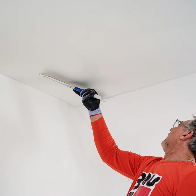 L'enduit au rouleau est liss&eacute; &agrave; l'aide d'une spatule de surface.