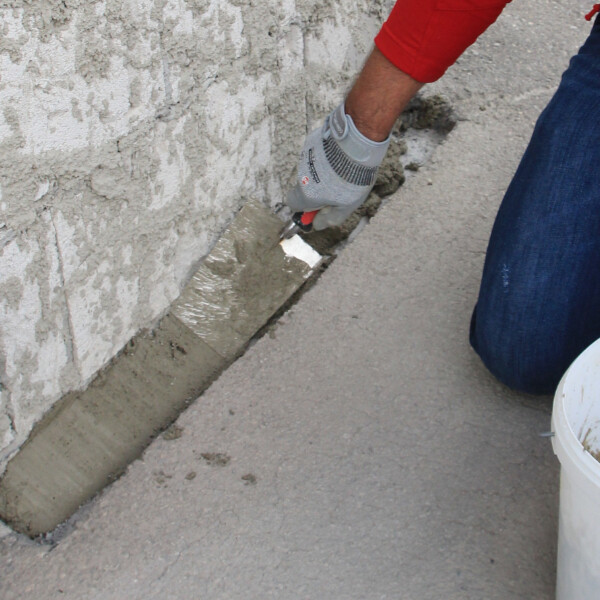 Zementmörtel für die Hohlkehle im Stoßbereich von aufsteigender Wand und Fundament auftragen